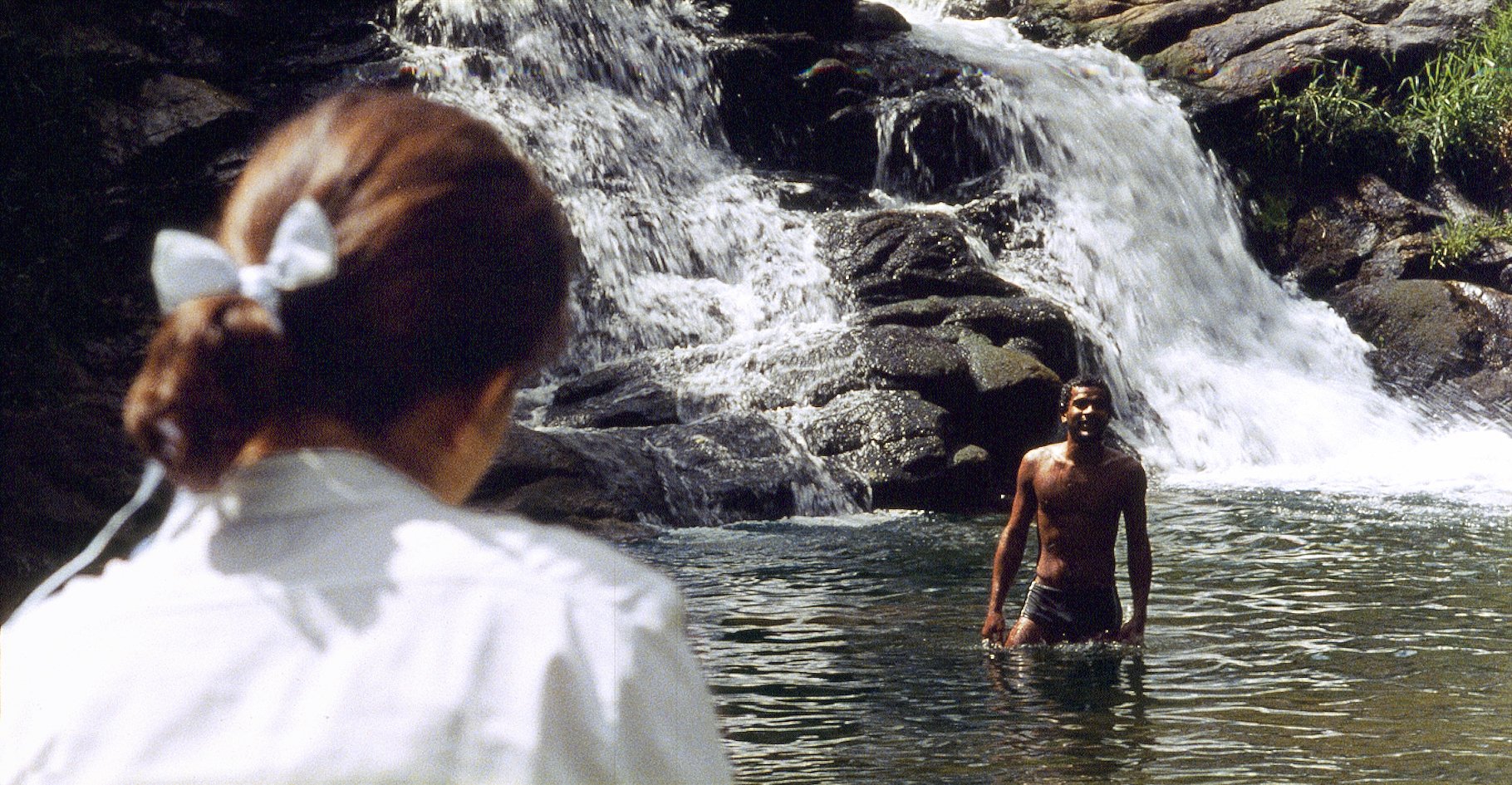 Cascade tropicale, deux personnages, plan large. Água Viva, court-métrage 35 mm, 2009. Mariah Teixeira et Samuel de Assis.