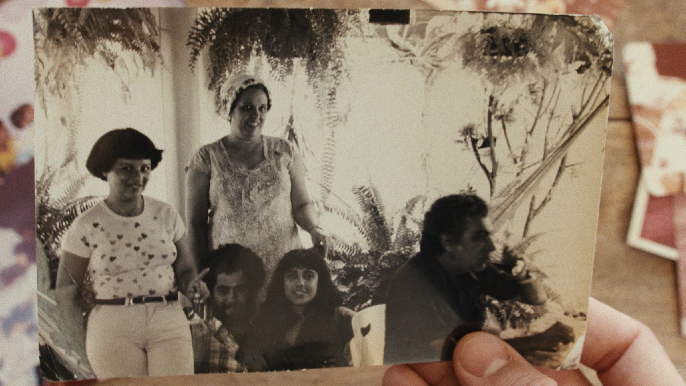 Photographie de groupe noir et blanc de la famille tenue dans une main. Plan rapproché.