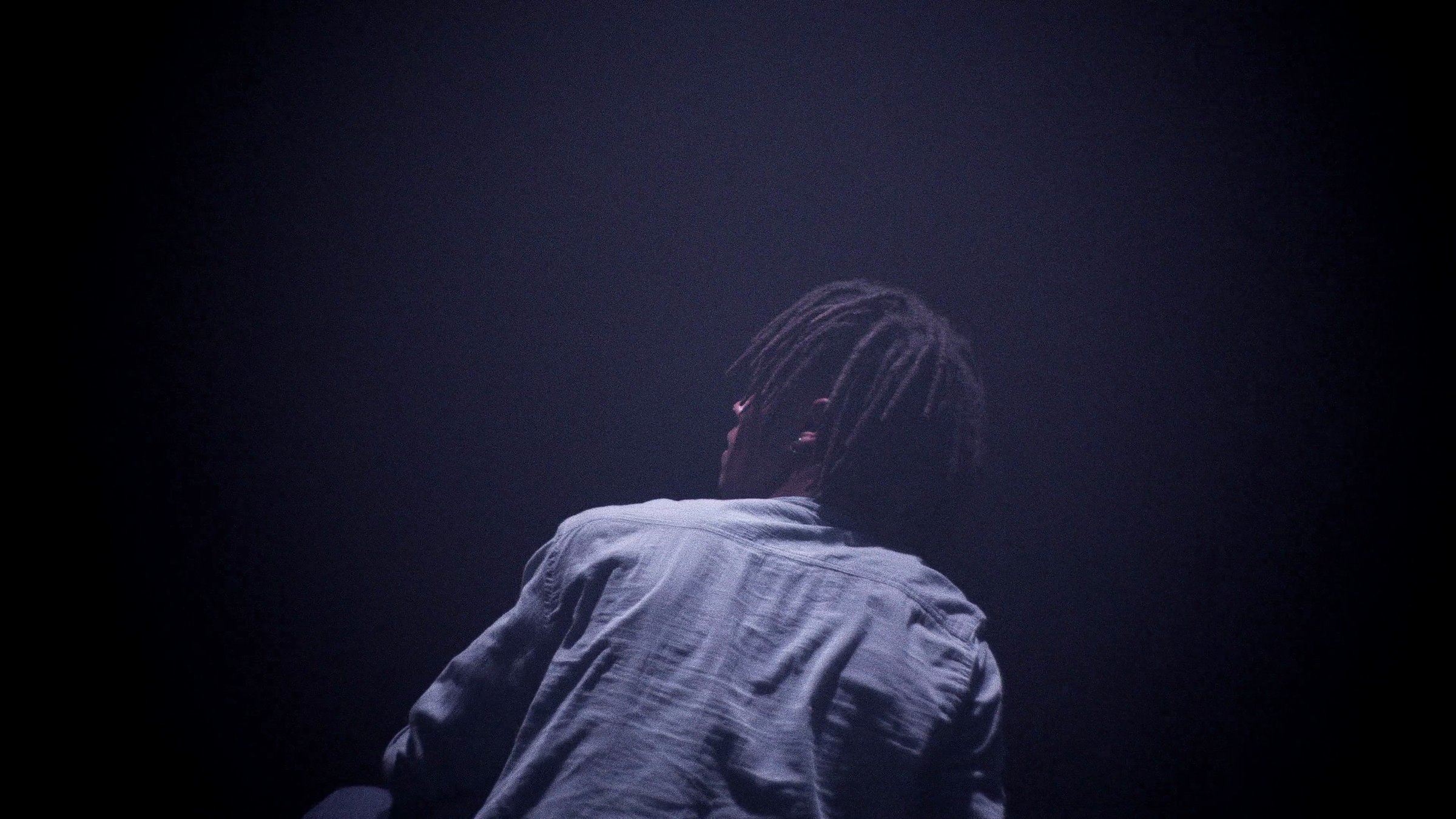 Danseur de dos, dreads, clair-obscur, plan moyen. Zéphyr, Mourad Merzouki, CCN de Créteil.