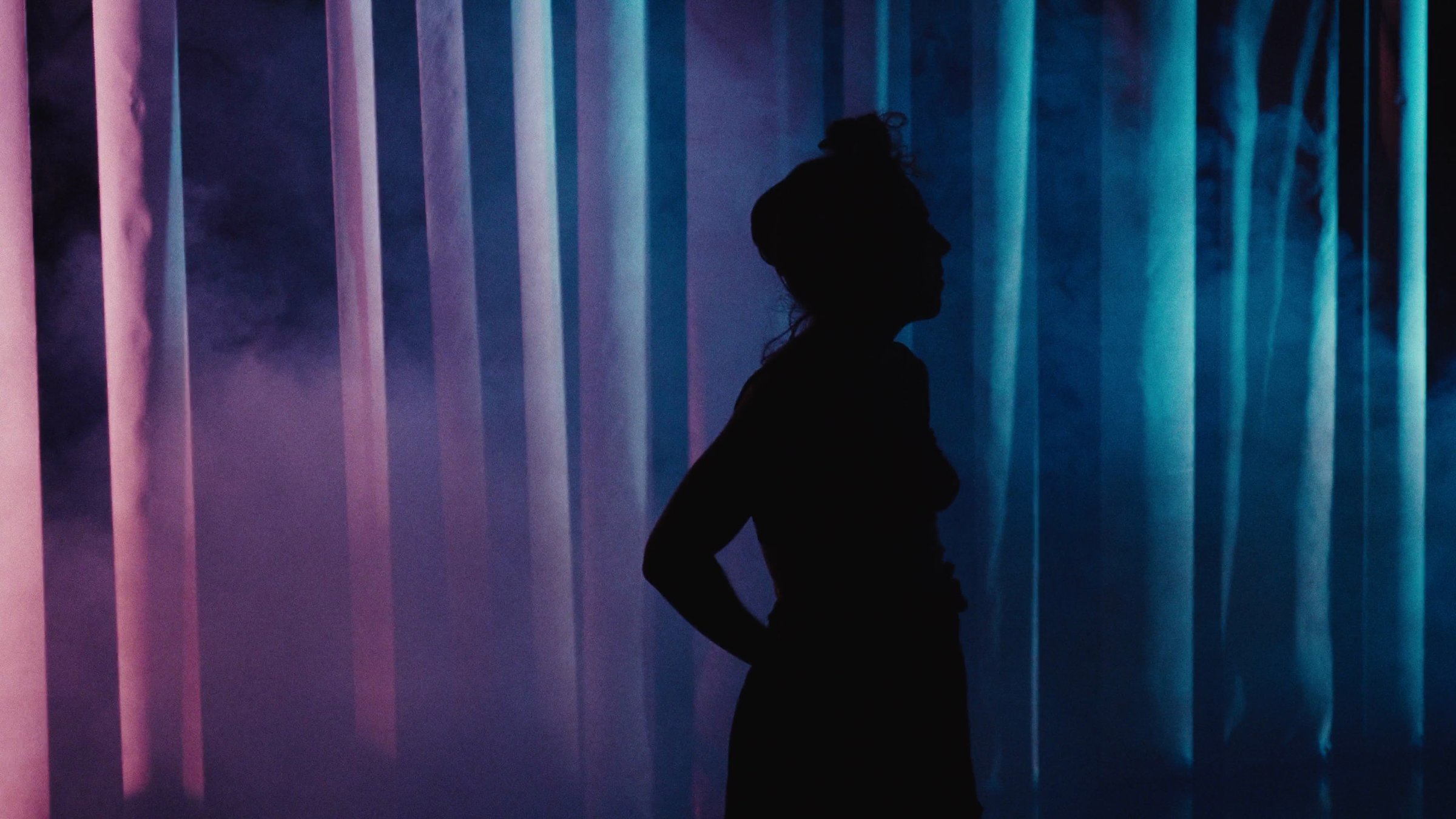 Silhouette de danseuse devant des rideaux colorés. CCN de Créteil.
